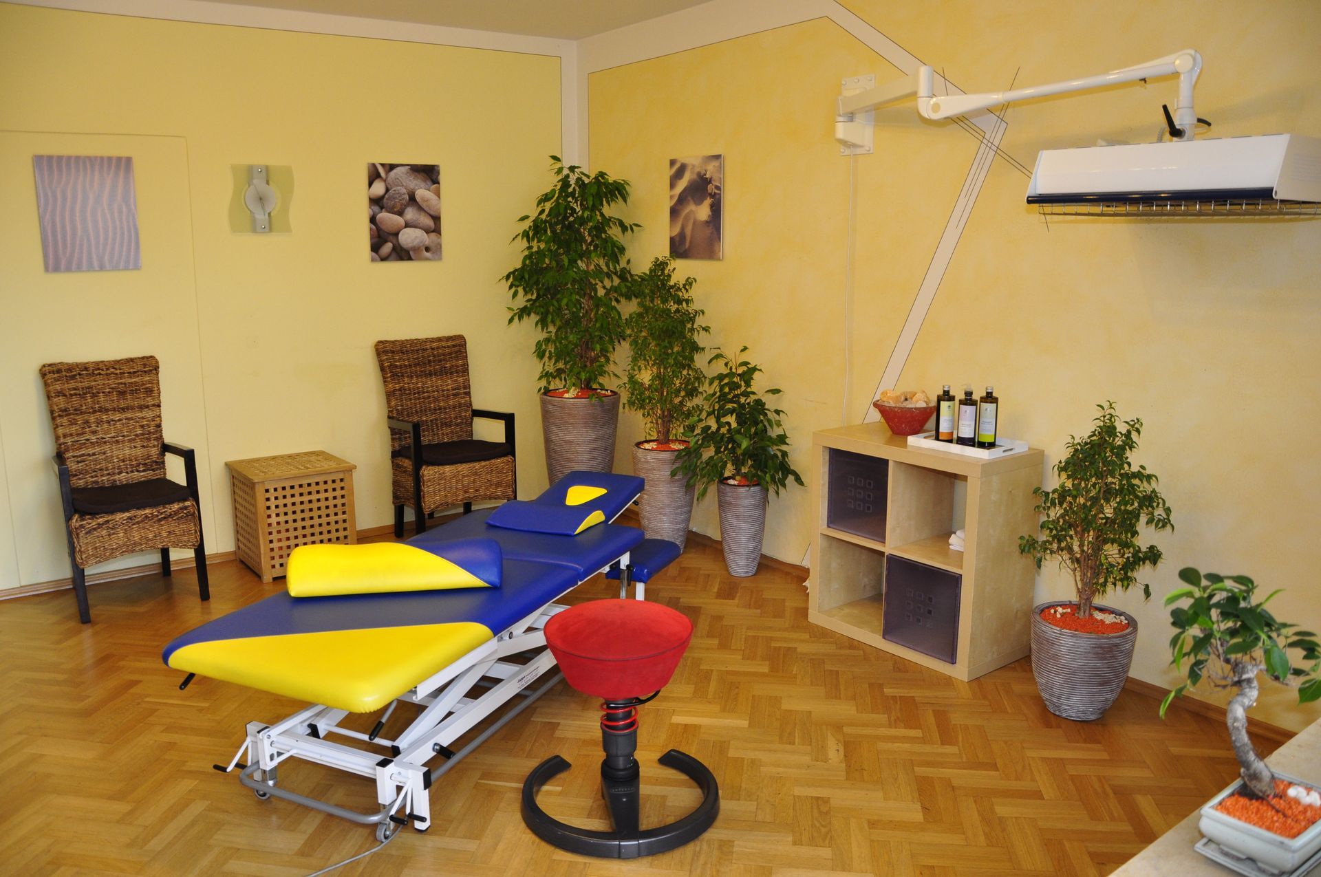 Großer Therapieraum mit Liegen, Stühlen und Trainingsbereich
