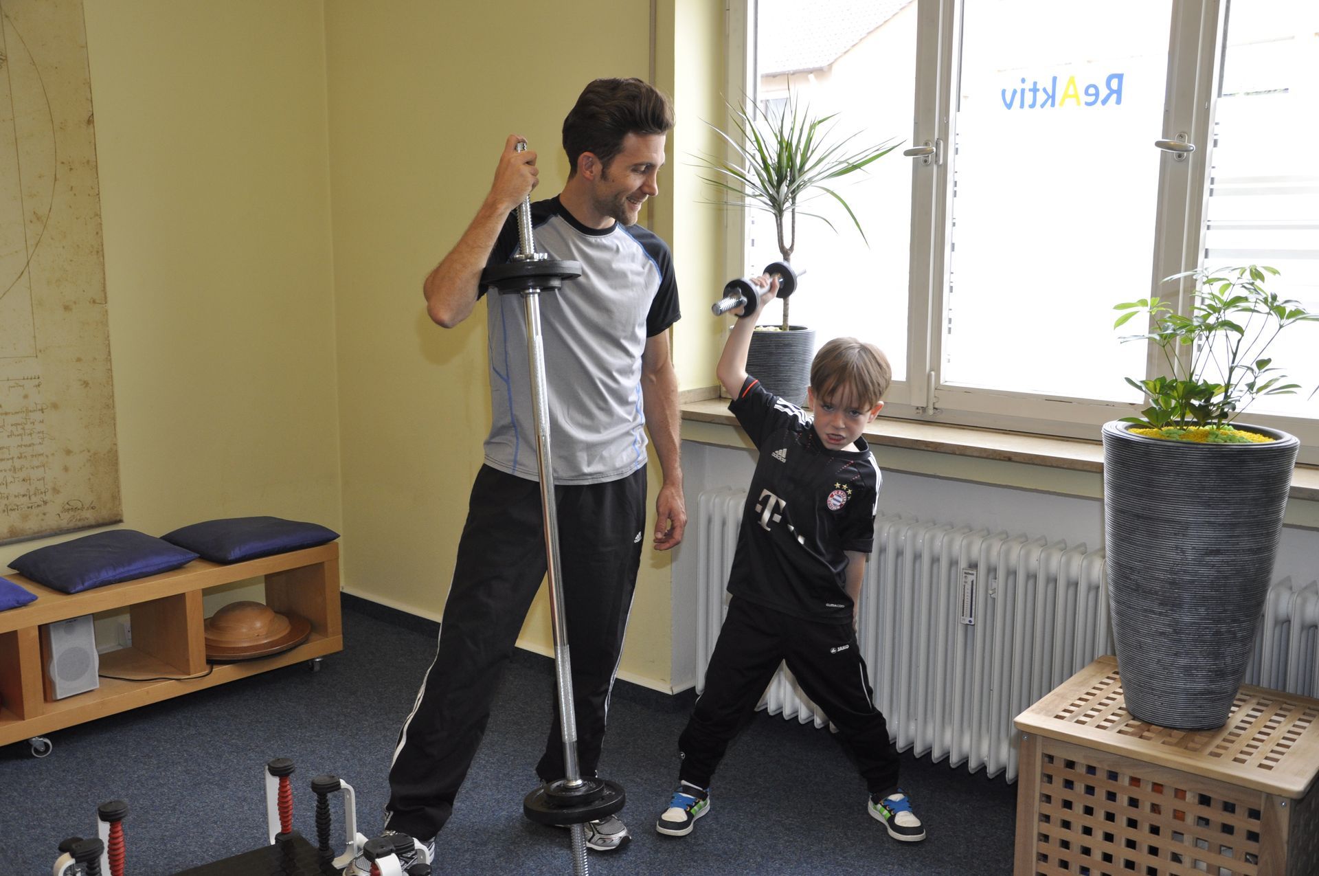 Therapeut unterstützt Patient beim Training mit Theraband