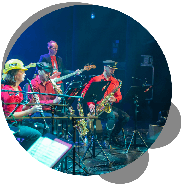 artiesten op een podium die verschillende instrumenten bespelen 
