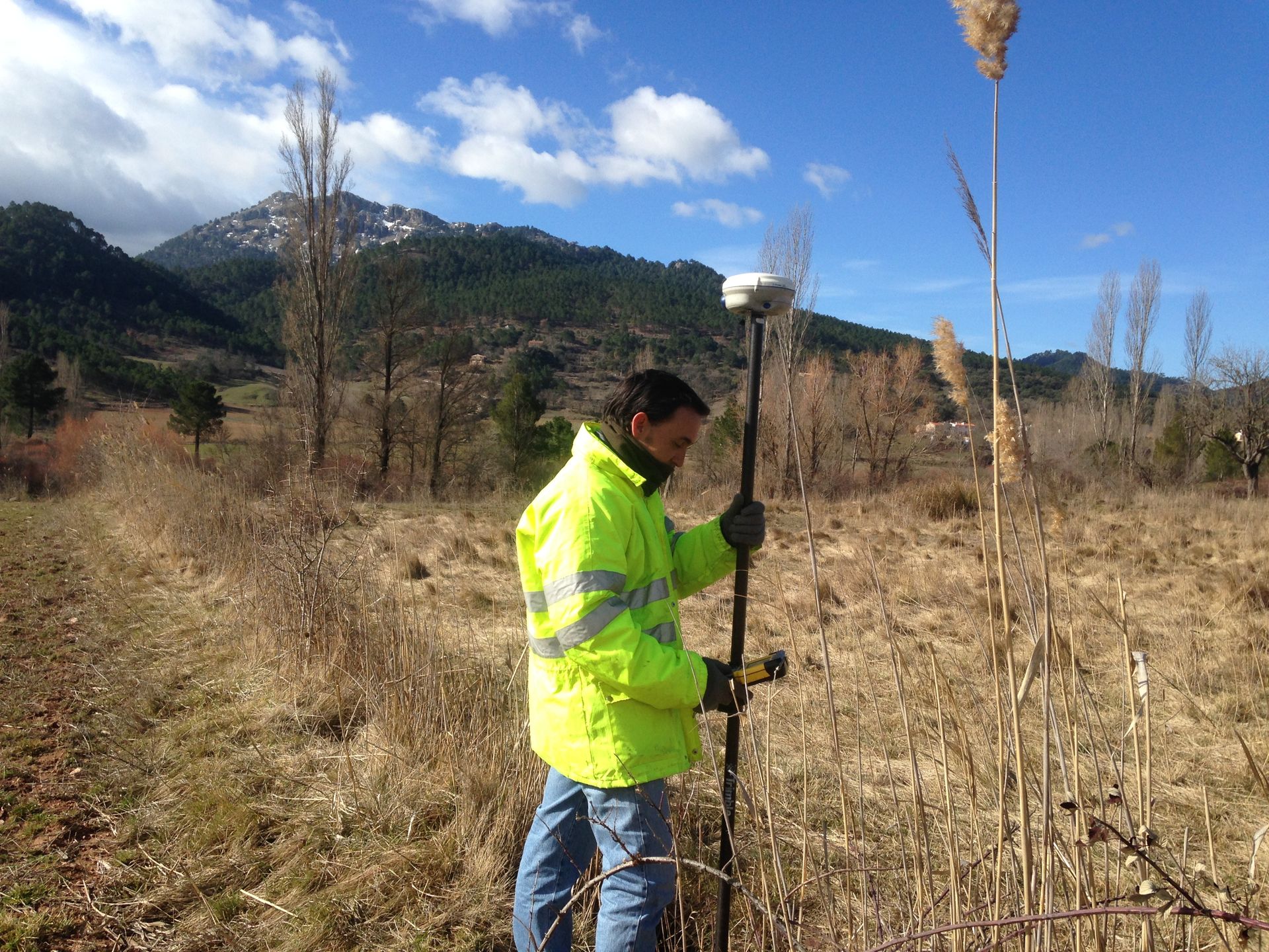 Aerogenerador en un campo, generando energía limpia. Paisaje agrícola al fondo.