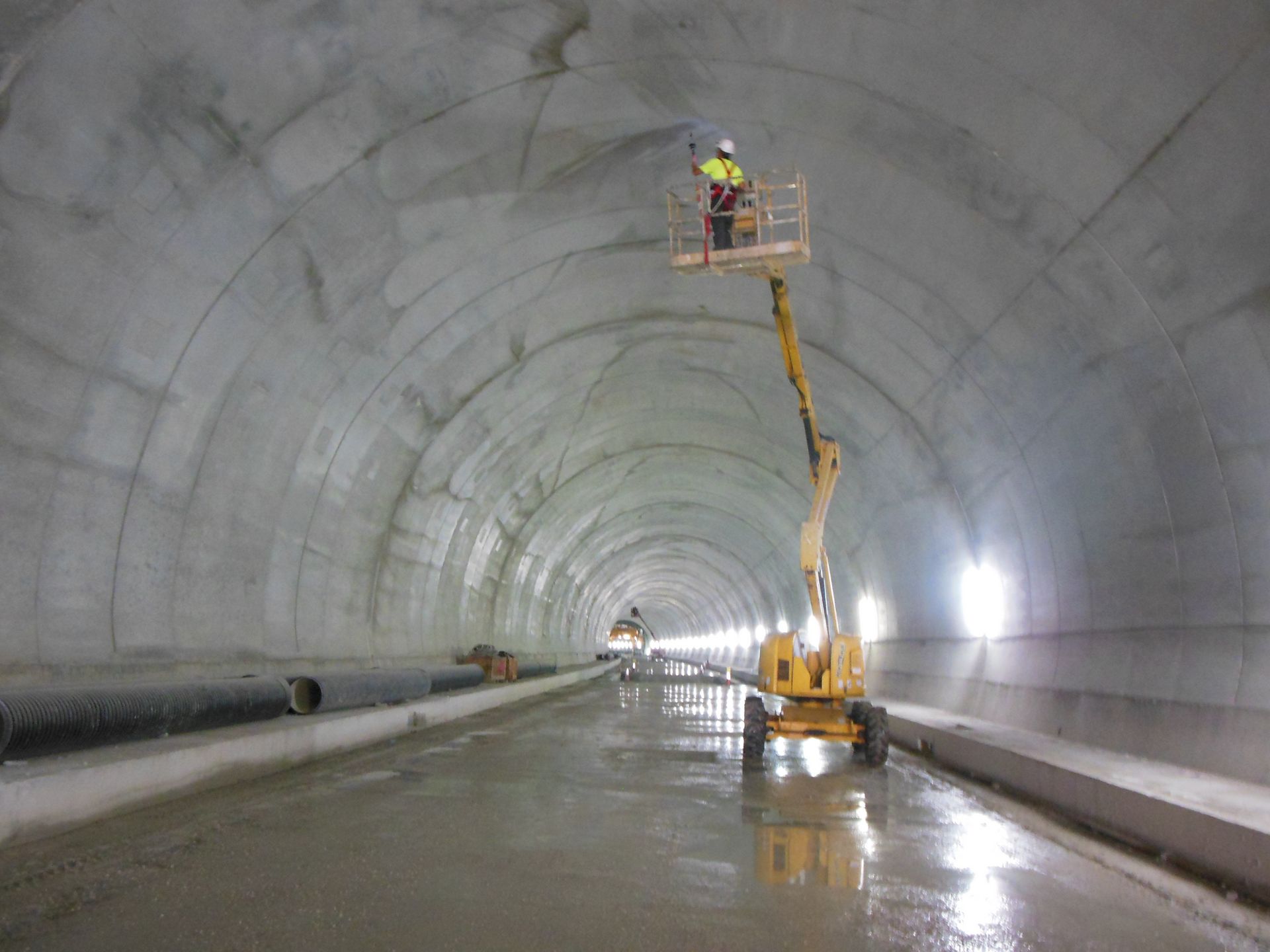 Un instrumento de medición sobre un trípode, delante de líneas y equipos de alta tensión.