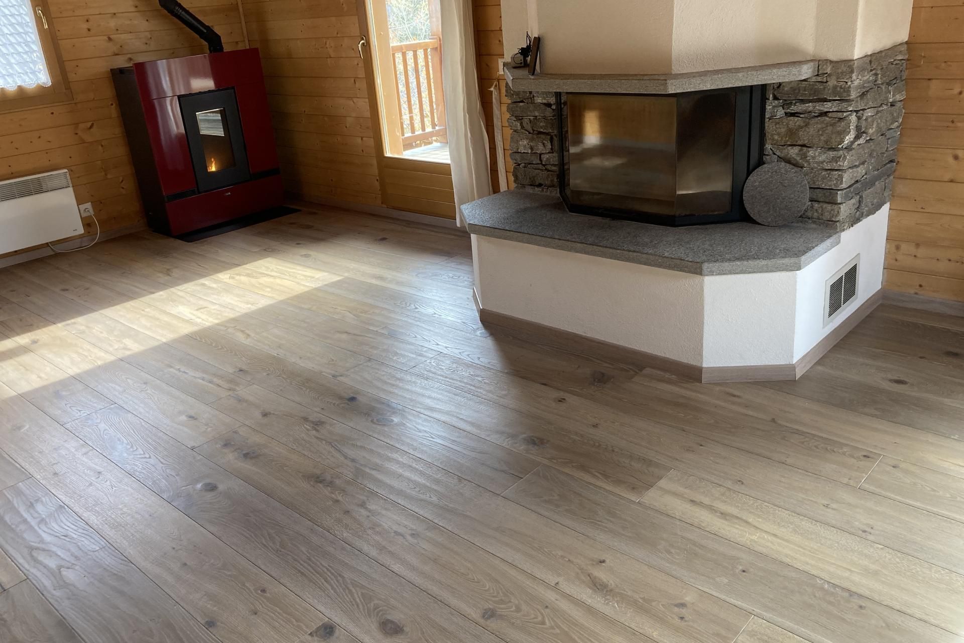 Un soggiorno con pavimento in legno e camino.