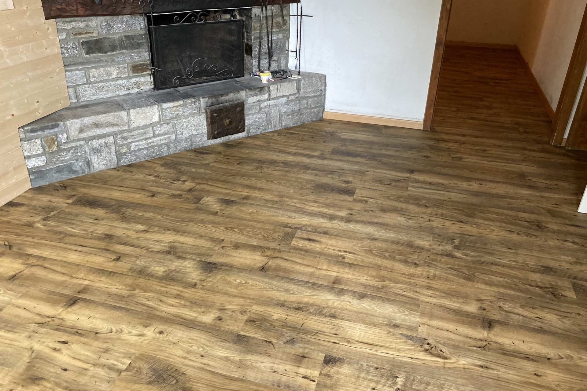 Un soggiorno con pavimento in legno e camino.