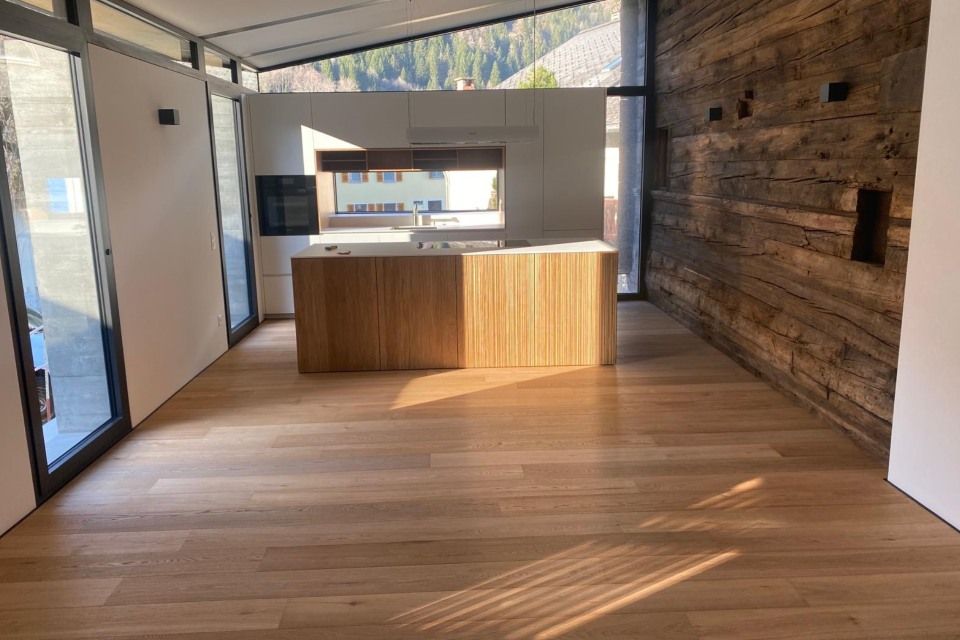 Una cucina con isola in legno e parete in legno.