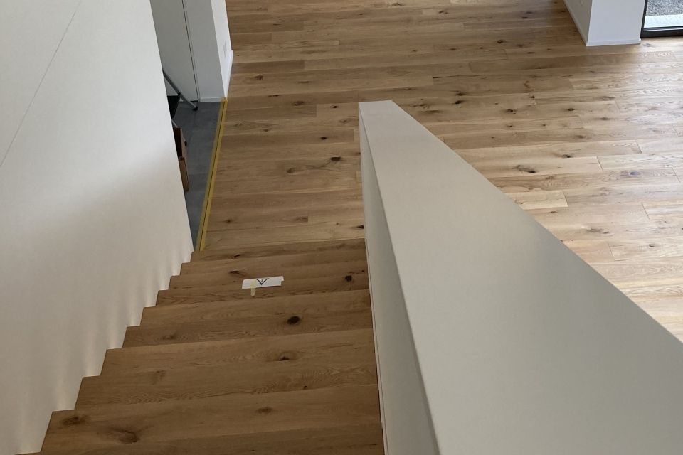 Una scala di legno con una ringhiera bianca in una casa.