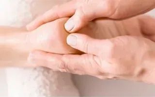 Manos masajeando un pie, posiblemente para terapia o relajación.