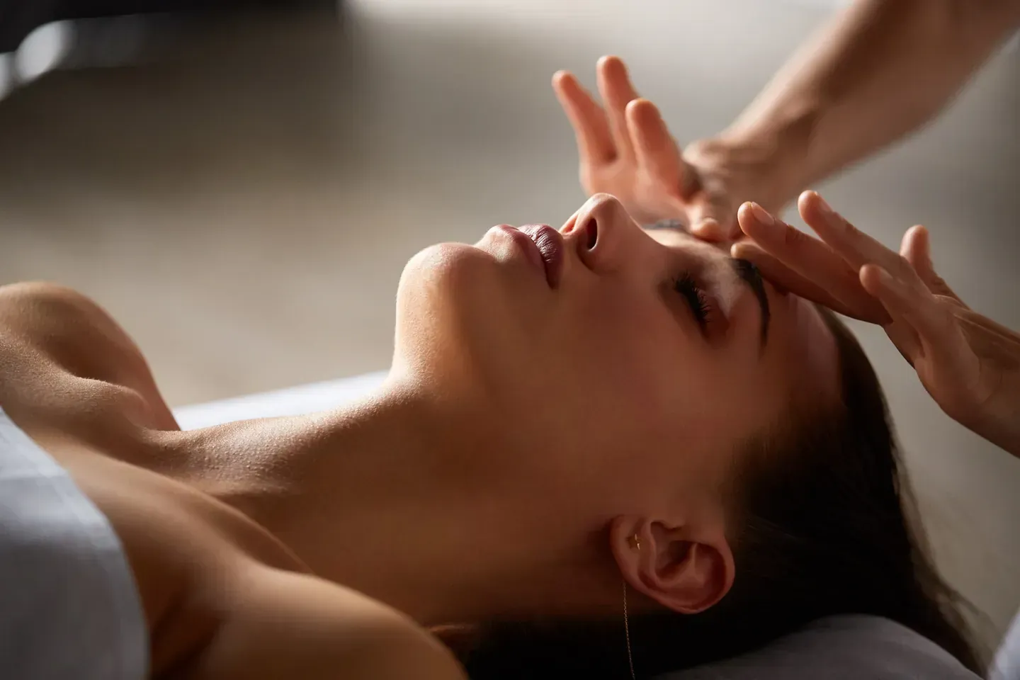 Una mujer está recibiendo un masaje facial en un spa.