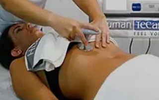 Una mujer está acostada en una cama recibiendo un masaje.