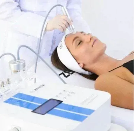 Una mujer está recibiendo un tratamiento de microdermoabrasión en su cara.