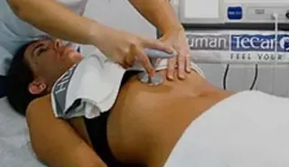 Una mujer está acostada en una cama recibiendo un masaje.