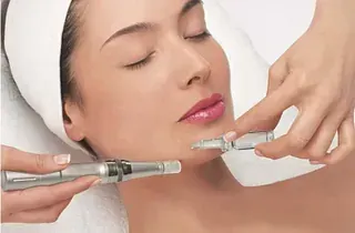 Una mujer está recibiendo un tratamiento de microdermoabrasión en su cara.