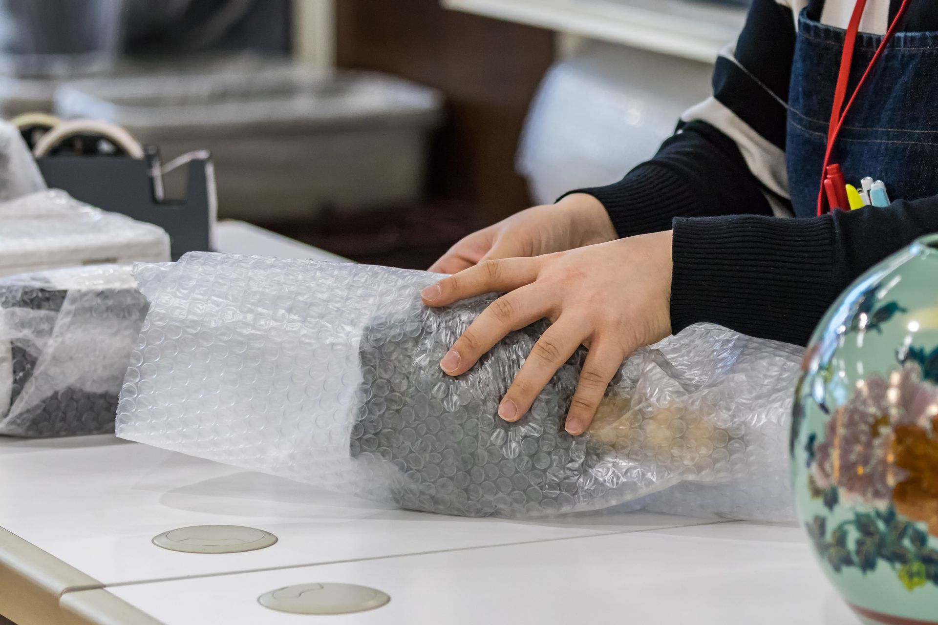 Une personne qui emballe un objet d'art