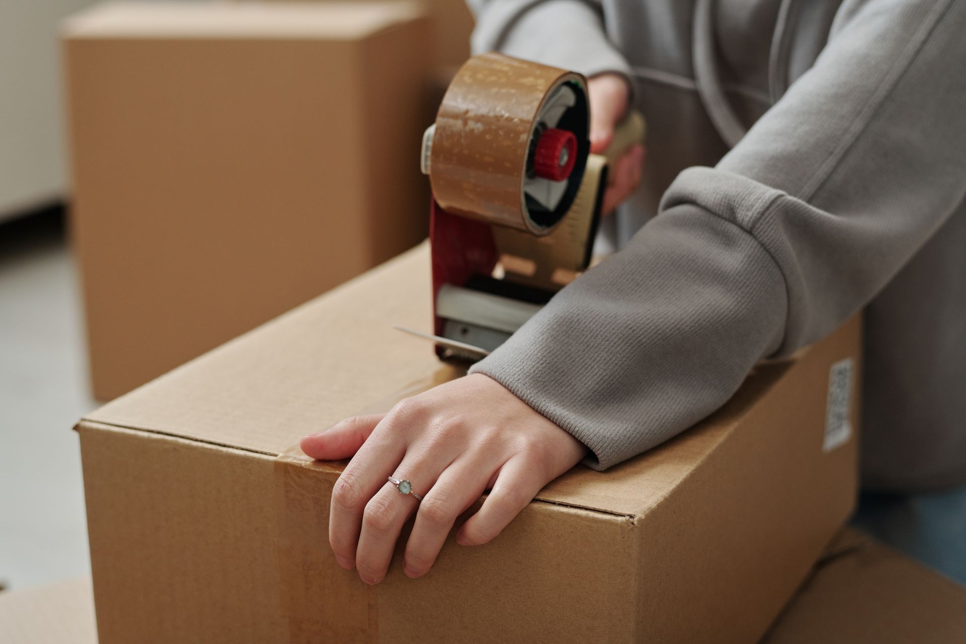 Une femme qui ferme des cartons avec de l'adhésif