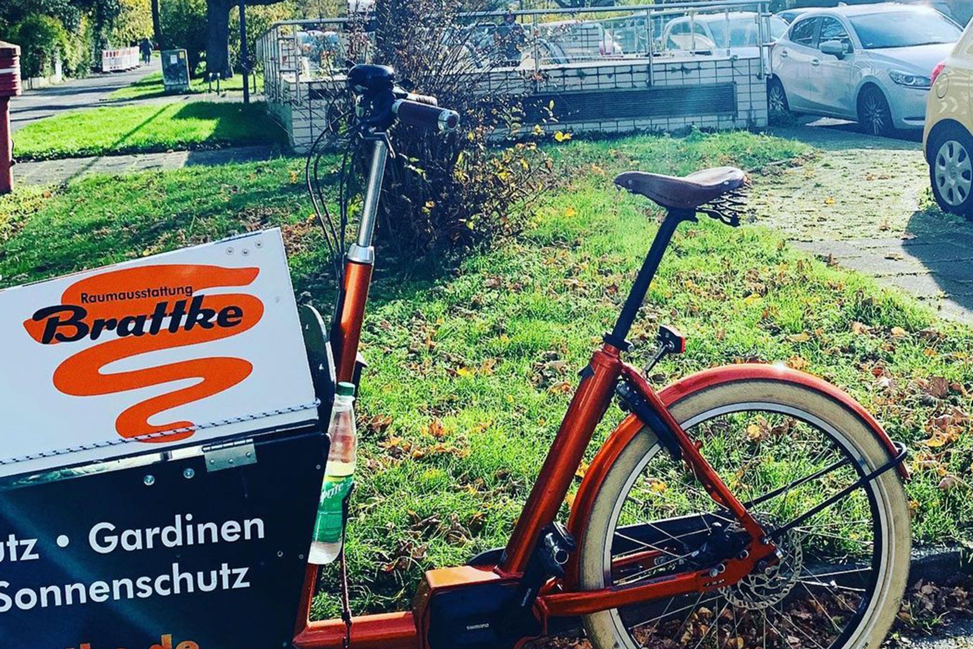 Ein Fahrrad steht neben einem Schild mit der Aufschrift Raumausstattung Brattke