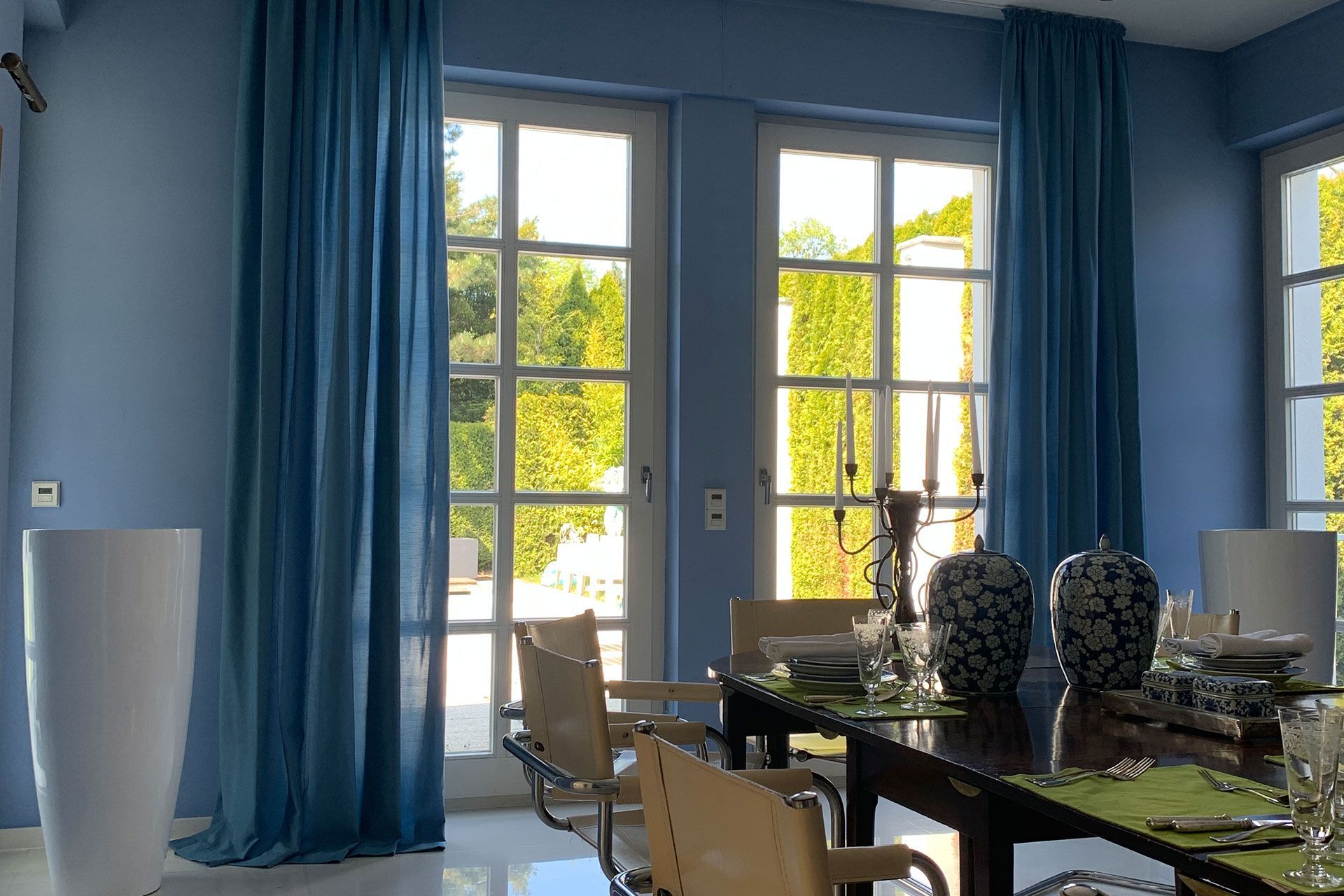 ein Esszimmer mit einem Tisch und Stühlen und blauen Vorhängen