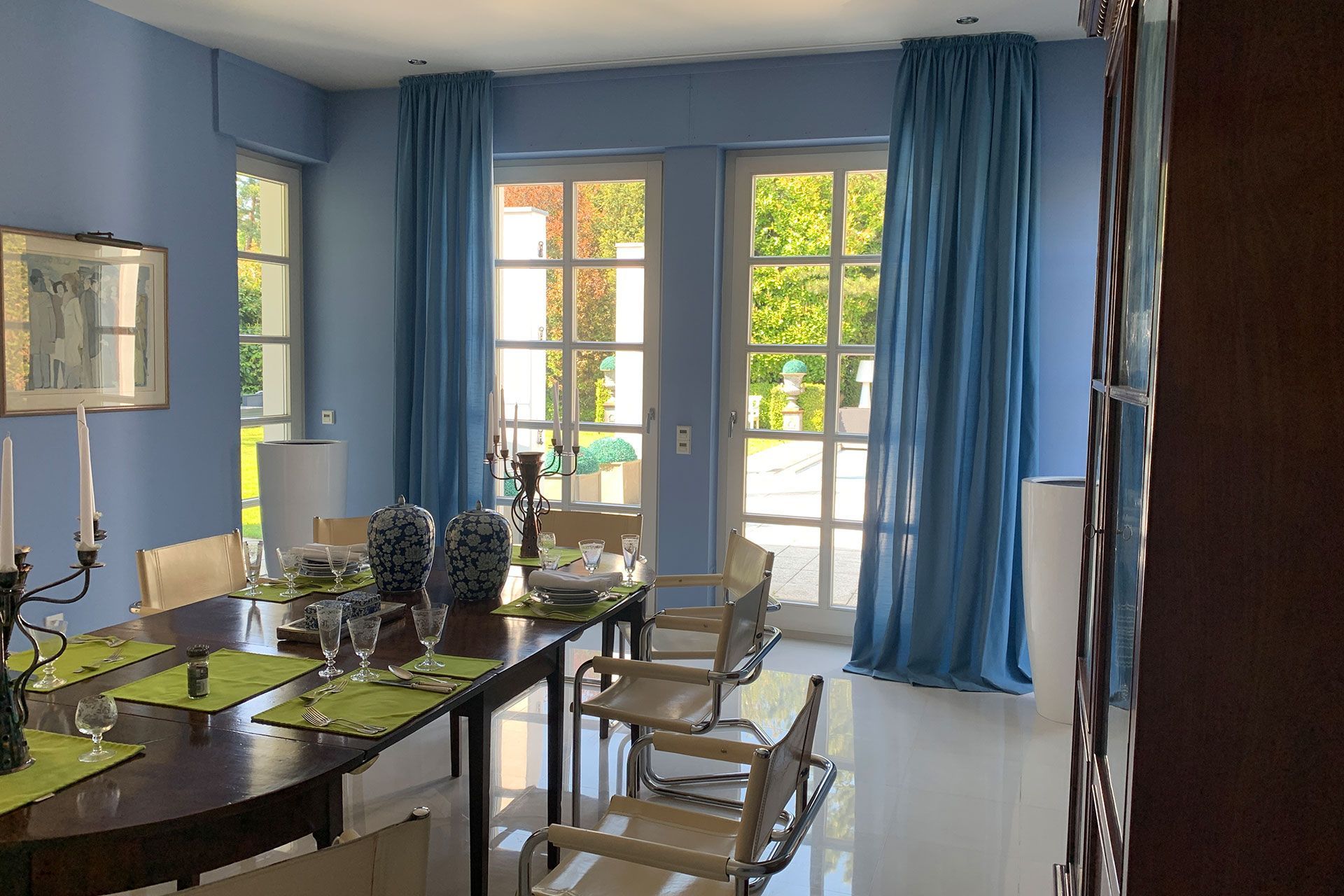 Ein Esszimmer mit blauen Wänden und blauen Vorhängen