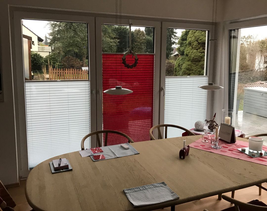 ein Esszimmer mit einem Tisch und Stühlen und roten Vorhängen