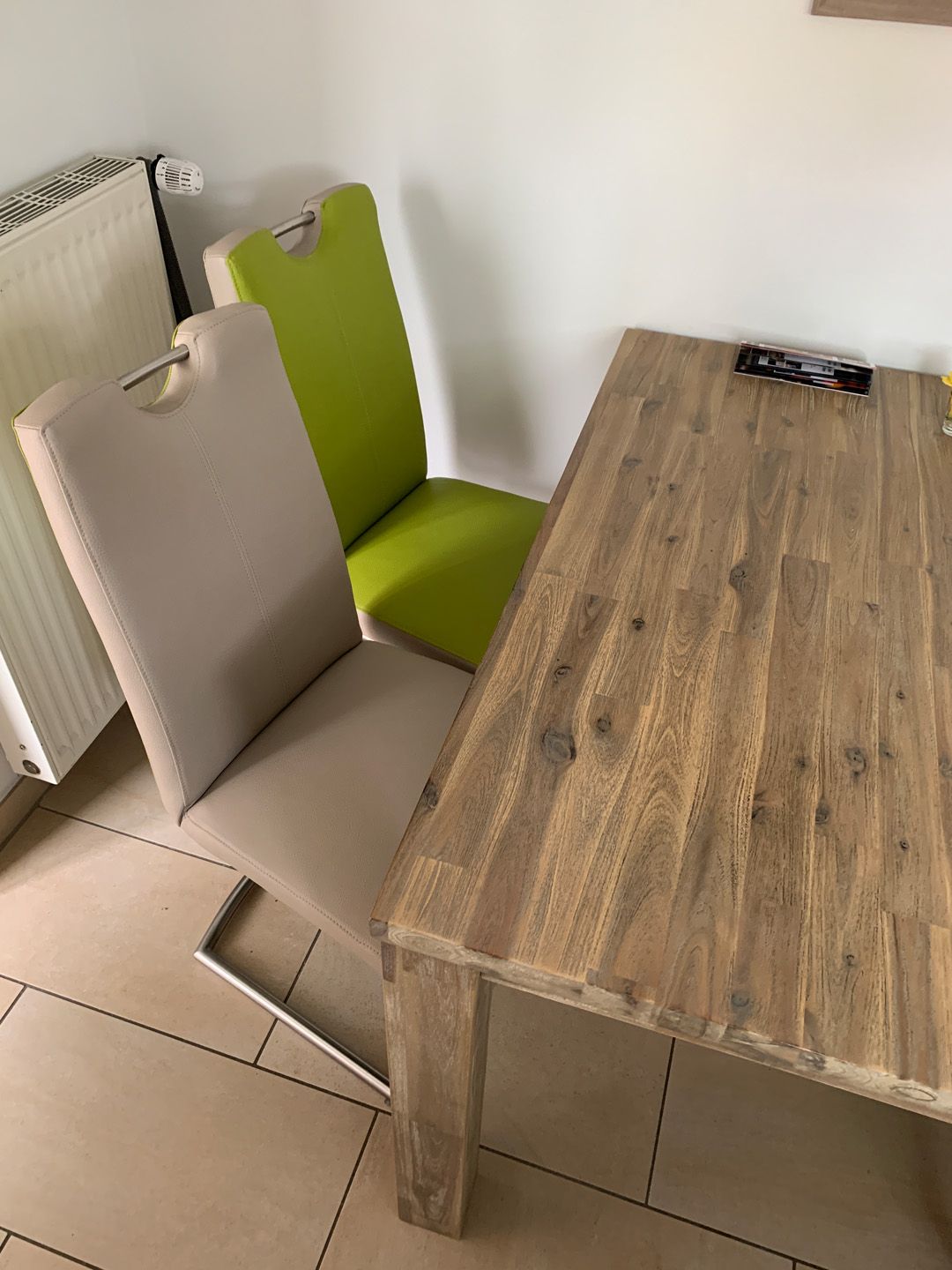 ein Holztisch mit zwei grünen Stühlen darauf