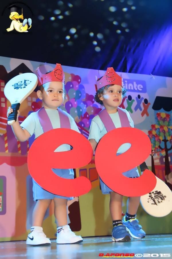 Dos niños pequeños sosteniendo grandes letras rojas ee