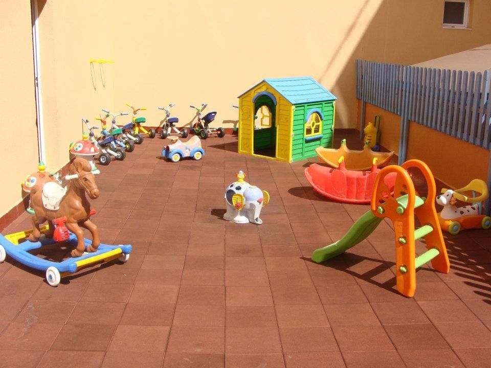 Un parque infantil con juguetes y un tobogán.