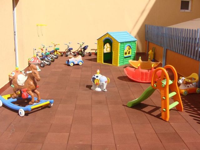 Un parque infantil con juguetes y un tobogán.