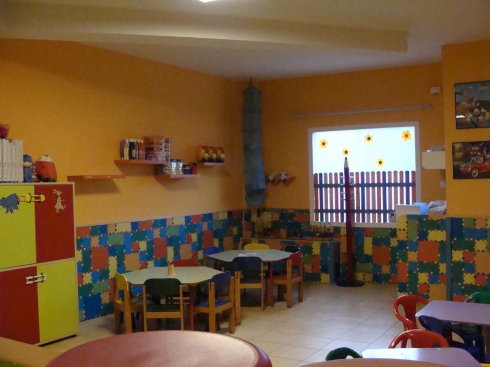 Un aula con mesas y sillas y una ventana.