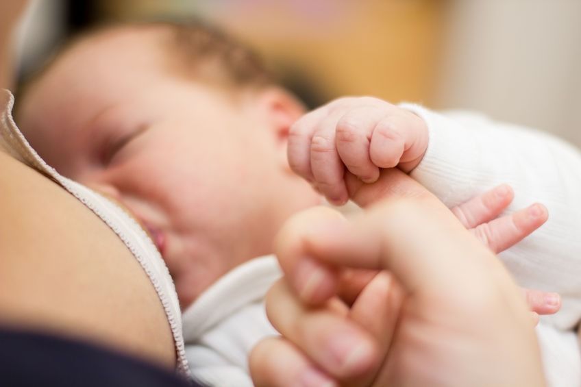 Un primer plano de una mujer amamantando a un bebé.