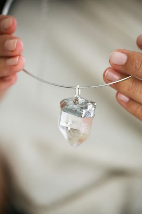 Palo santo humeante, vela encendida, cristales y un cuenco decorativo sobre una superficie texturizada.