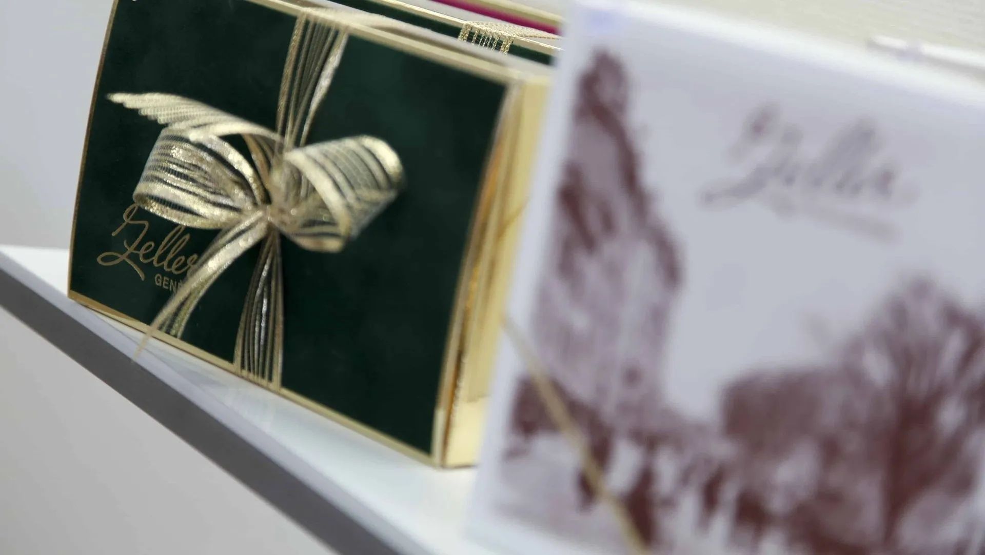 Une boîte verte avec un noeud doré et le mot bonjour dessus