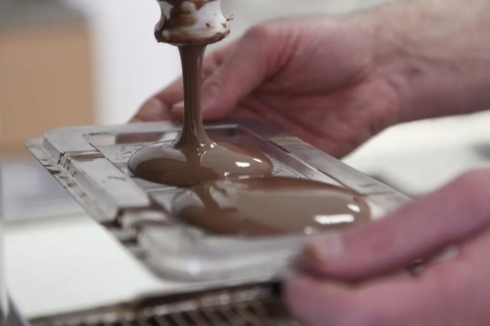 Une personne verse du chocolat dans un moule.