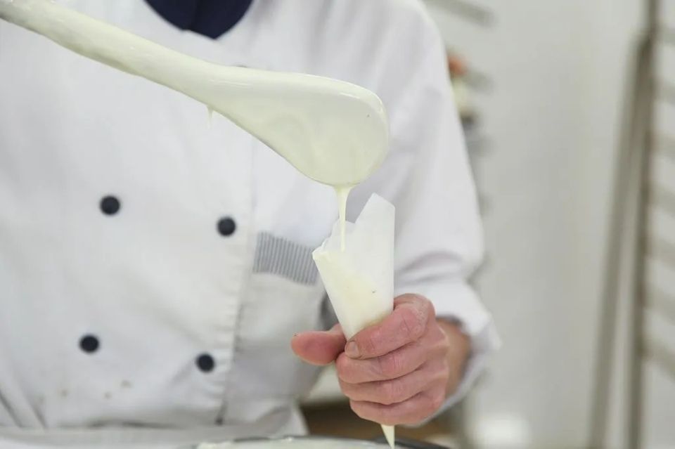 Un chef verse du glaçage dans une poche à douille.