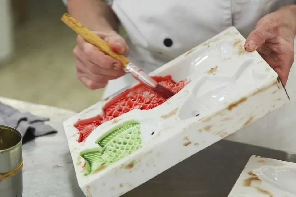 Une personne peint un moule avec un pinceau.