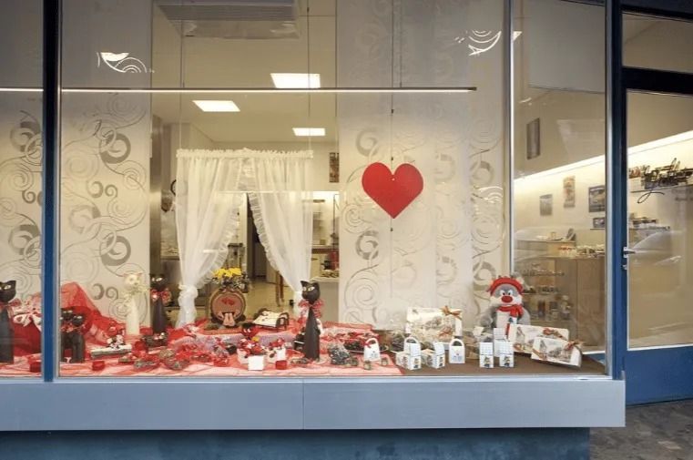 Une vitrine de magasin avec un cœur rouge suspendu au plafond.