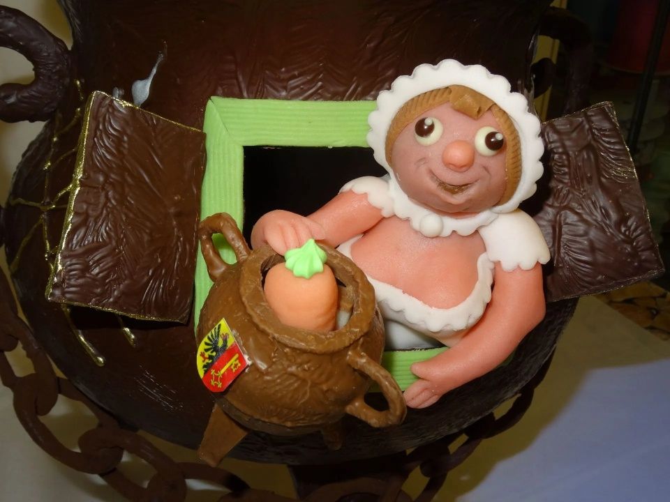 Une figurine d'une femme tenant un pot avec une carotte dedans