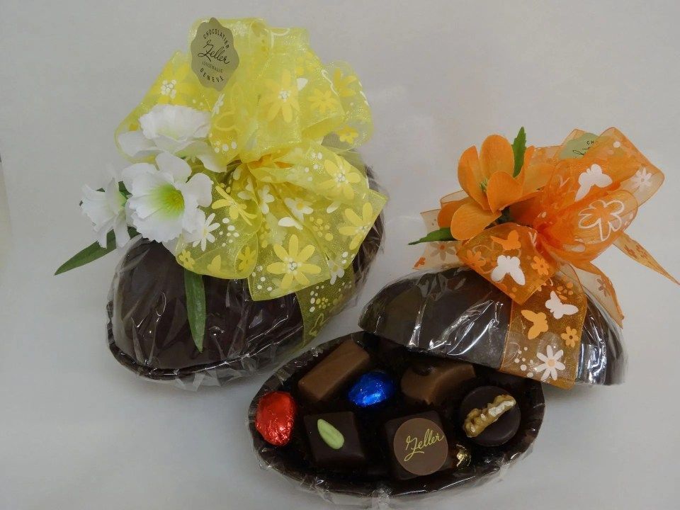 Deux œufs en chocolat sont emballés dans du plastique avec des fleurs et des nœuds