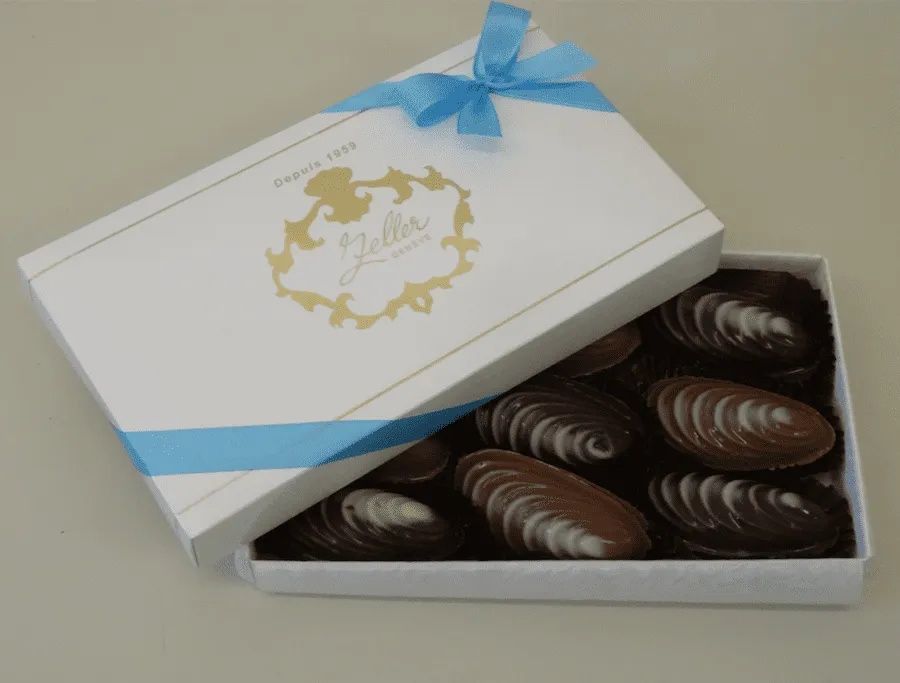 Une boîte de chocolats avec un ruban bleu dessus