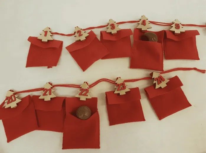 Une chaîne d'enveloppes rouges avec des arbres en bois dessus