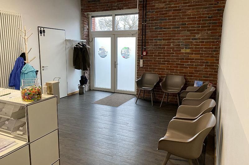 Ein Wartezimmer mit Stühlen und einer Ziegelwand