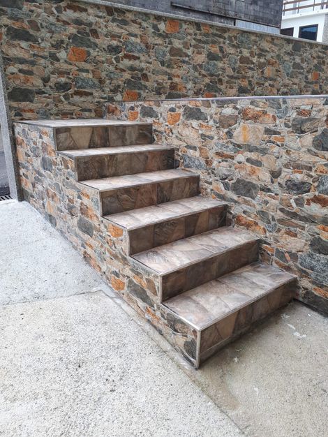 Un conjunto de escaleras que conducen a un muro de piedra.