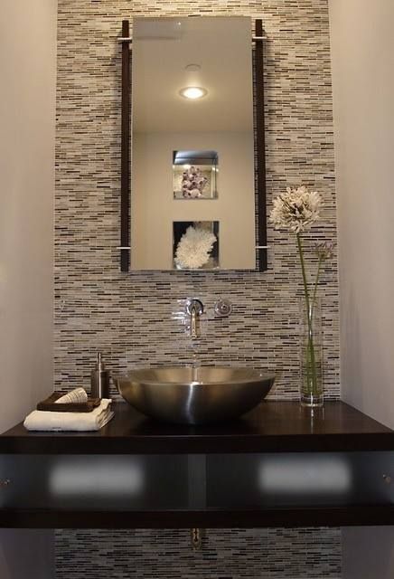 Un baño con un lavabo y un espejo en la pared.