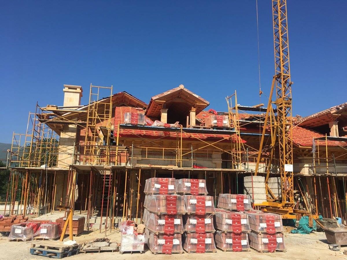 Un gran edificio en construcción con una grúa al fondo.