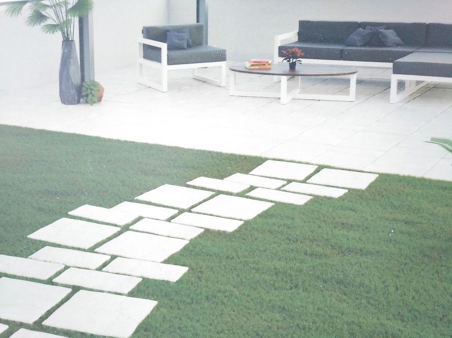 Una pasarela de ladrillos que conduce a una sala de estar con un sofá y sillas.