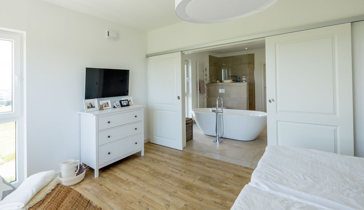 ein Schlafzimmer mit einem Fernseher und einer Badewanne