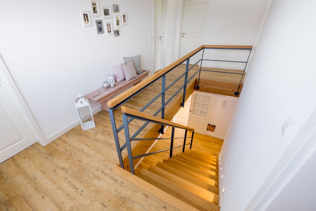 eine Treppe mit einem Metallgeländer und einem Holzhandlauf
