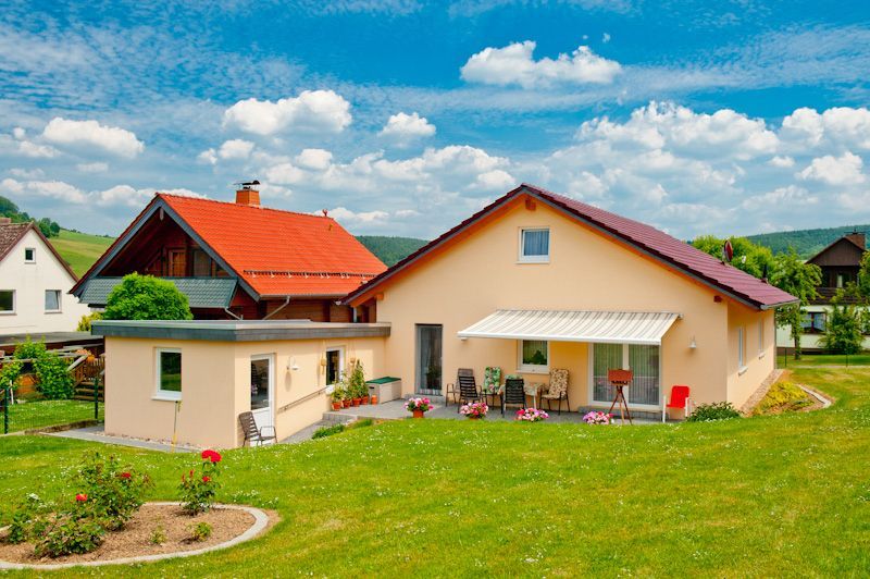 ein Haus mit einem roten Dach und einer weißen Veranda
