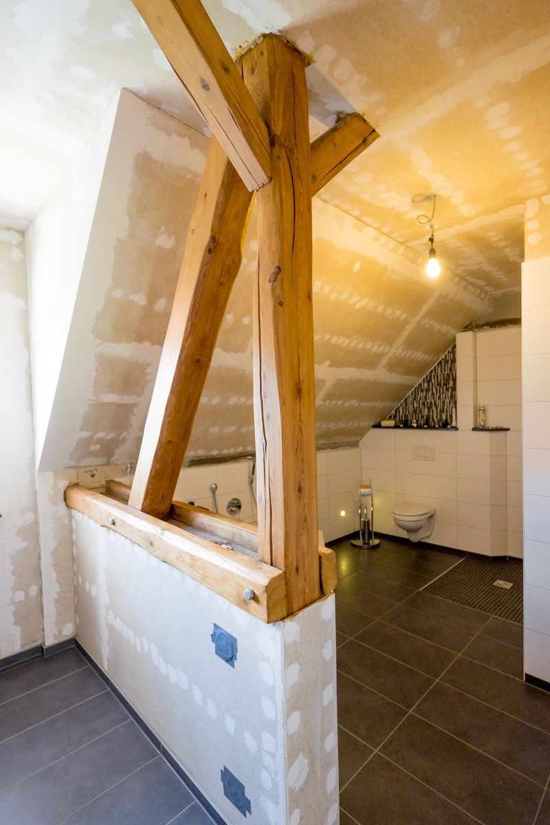 ein Badezimmer mit einem Holzbalken an der Decke