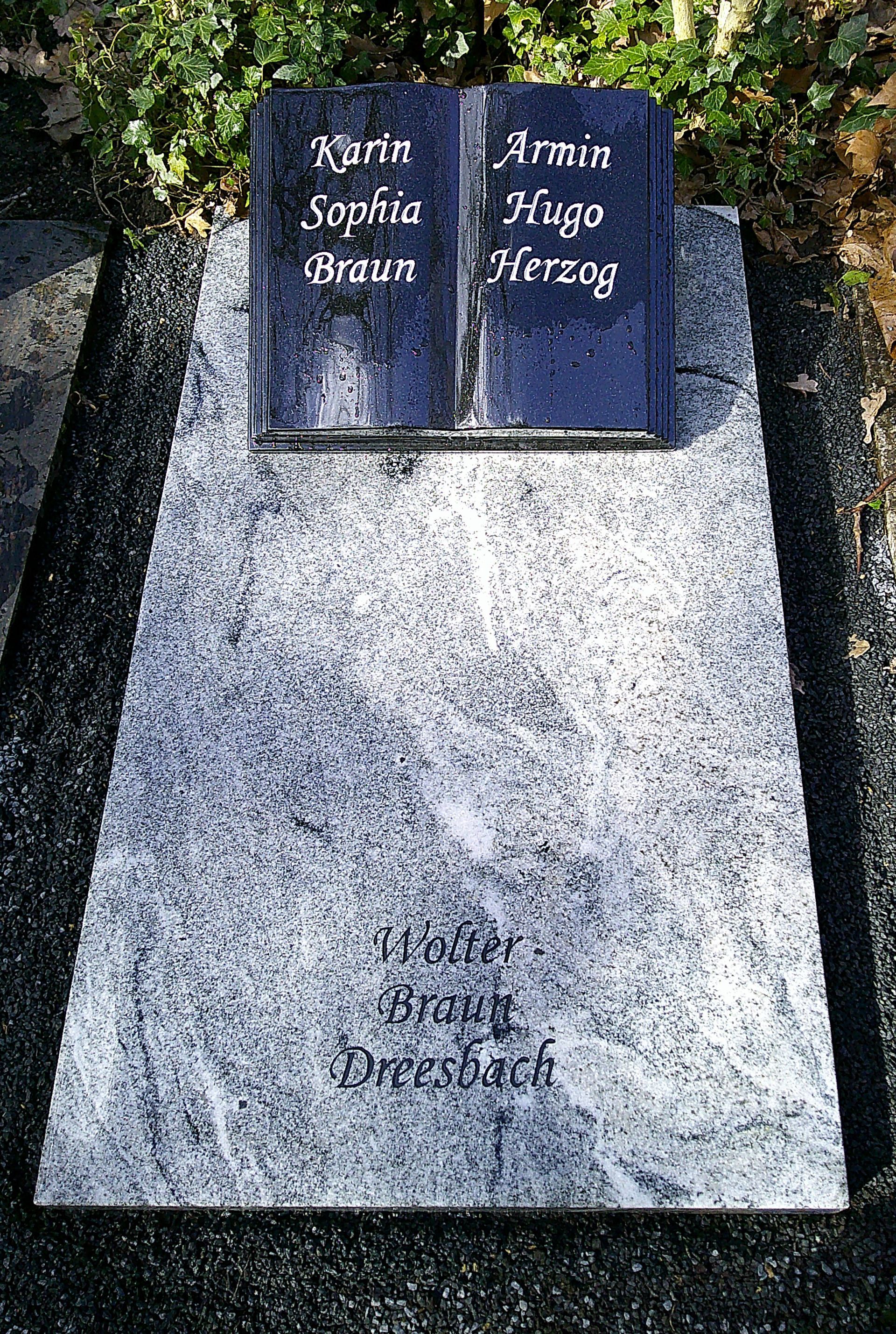 Grabstein: Buchförmiger Aufsatz mit den Namen Karen Sophia Braun und Armin Hugo Herzog auf einer größeren grauen Granitplatte.