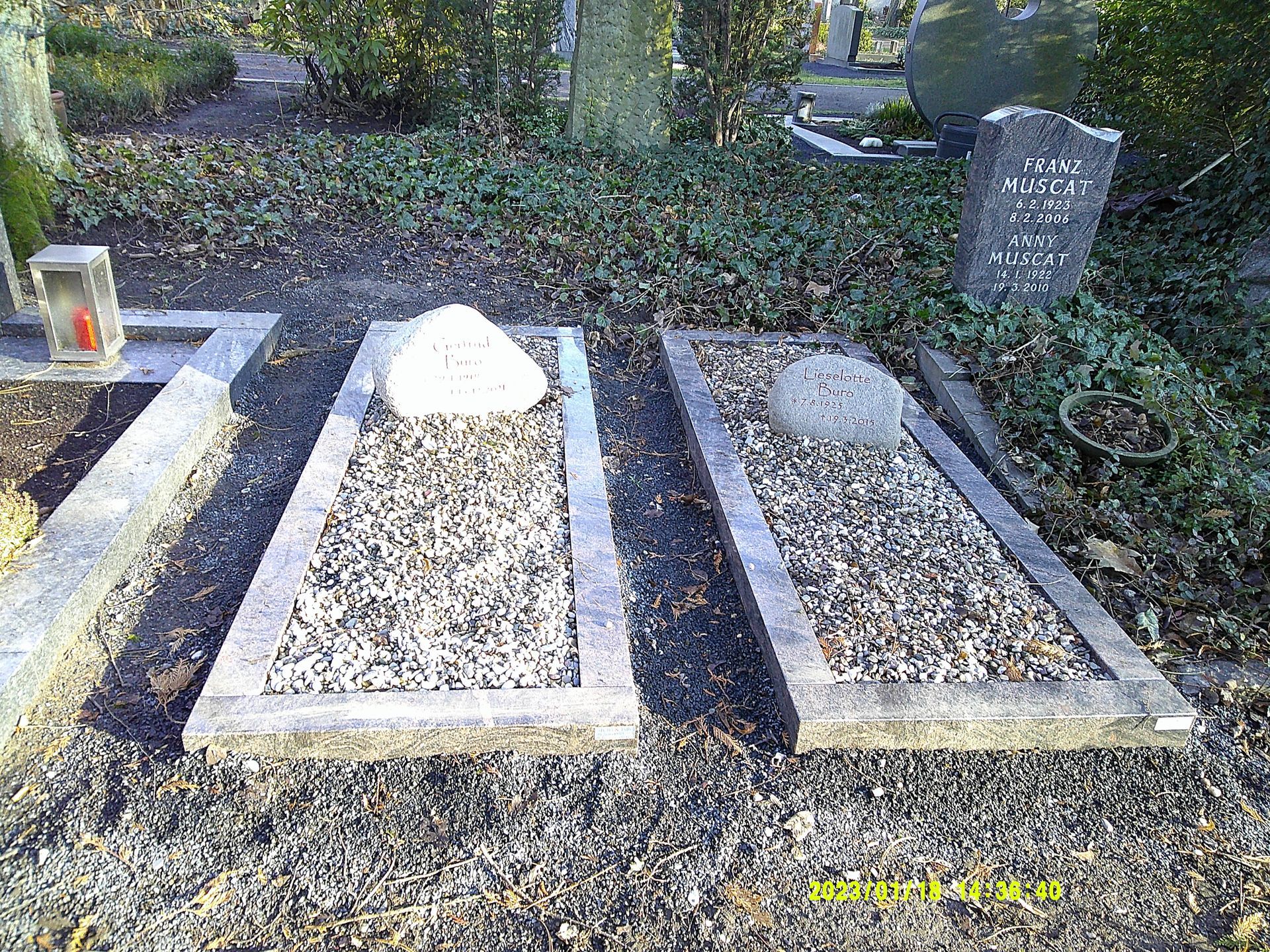 Gräber mit Grabsteinen und Steinabdeckungen in einer Friedhofsanlage.