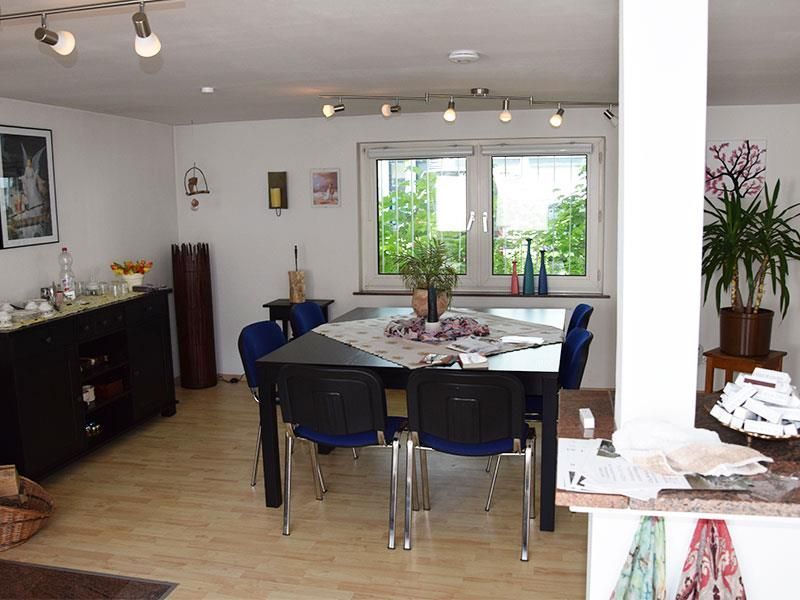 Ein Esszimmer mit Tisch und Stühlen und einem Fenster