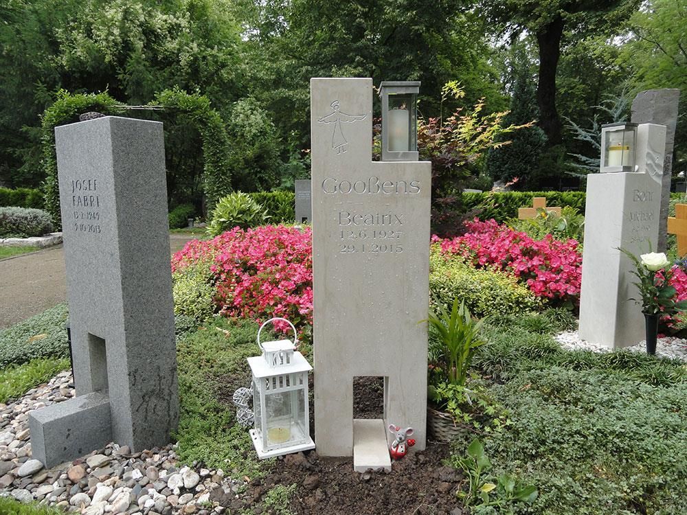 Ein Grab auf einem Friedhof mit einer Laterne und Blumen